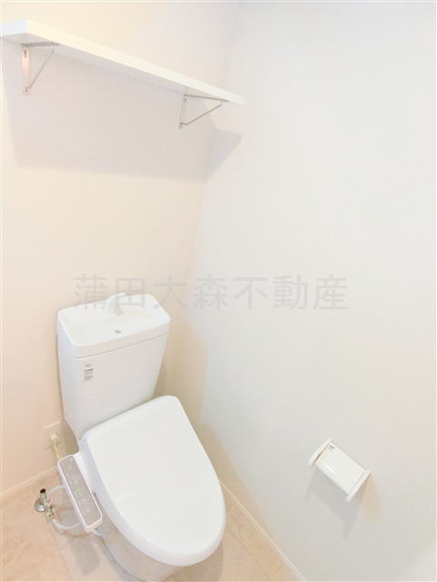 トイレ　棚と温水洗浄便座付きのトイレ