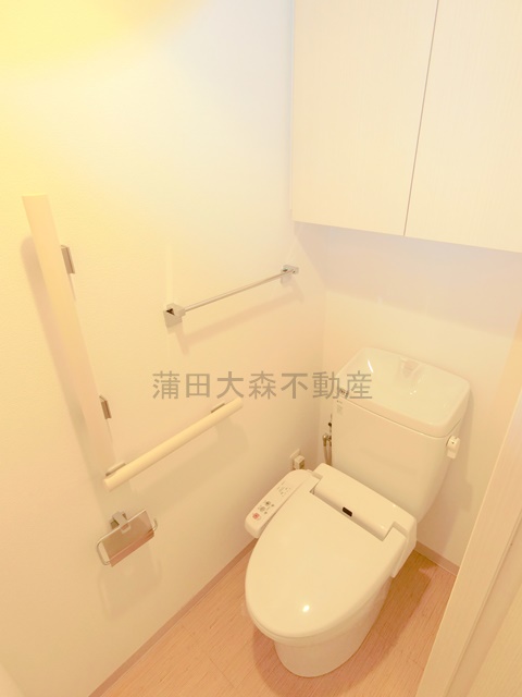 トイレ　吊戸棚と温水洗浄便座付きのトイレ
