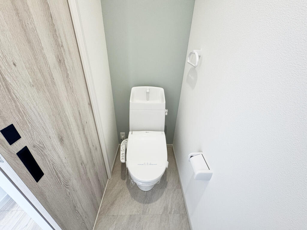 トイレ　ホワイトウッドの扉に合うアクセントカラー壁紙のトイレ