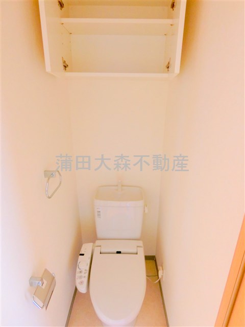 トイレ　吊戸棚と温水洗浄便座付きのトイレ