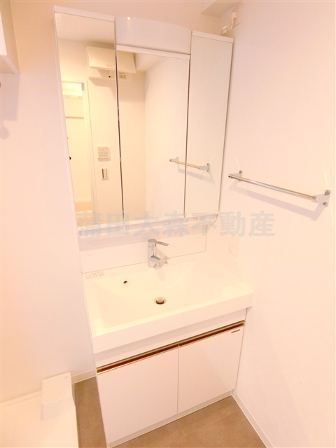 洗面設備　洗面脱衣所　3面鏡の独立洗面台　棚収納付きの洗濯機置き場