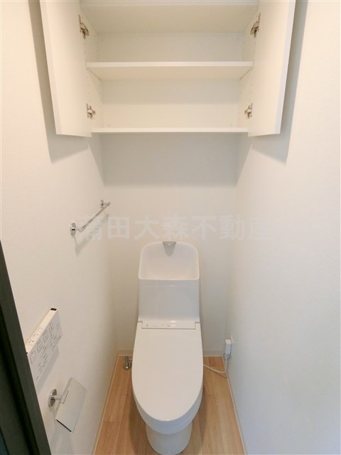 トイレ　吊戸棚と温水洗浄便座付きのトイレ