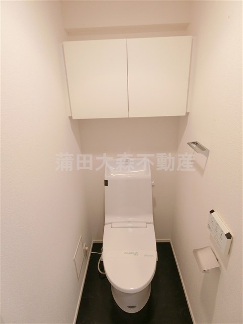 トイレ　吊り戸棚収納と温水洗浄便座付きのトイレ