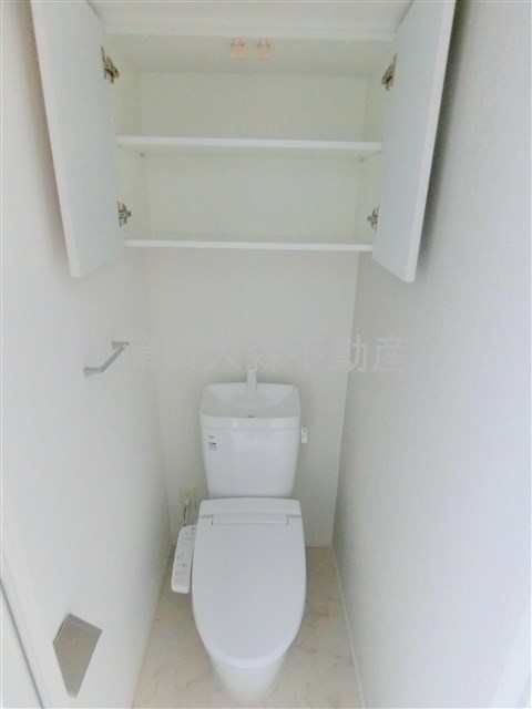 トイレ　吊戸棚収納と温水洗浄便座付きのトイレ