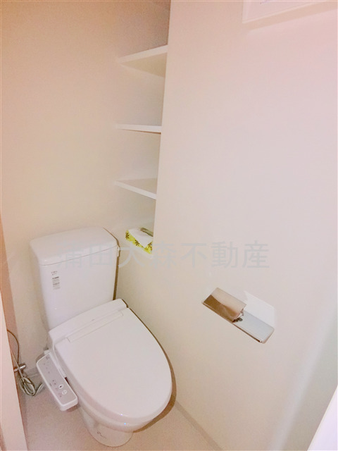 トイレ　棚と温水洗浄便座付きのトイレ
