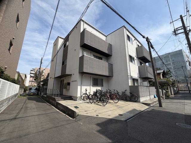 その他　鉄骨造３階建て、駐輪スペースのあるマンション外観