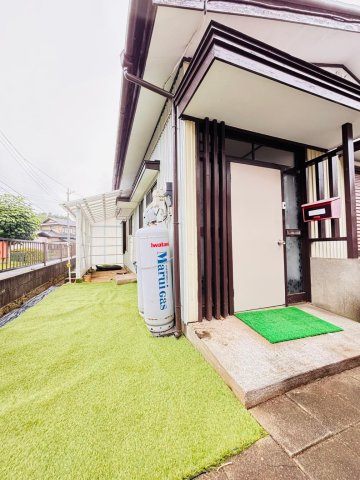 建物外観　人工芝。奥に見えるのは屋根付き駐輪場です。