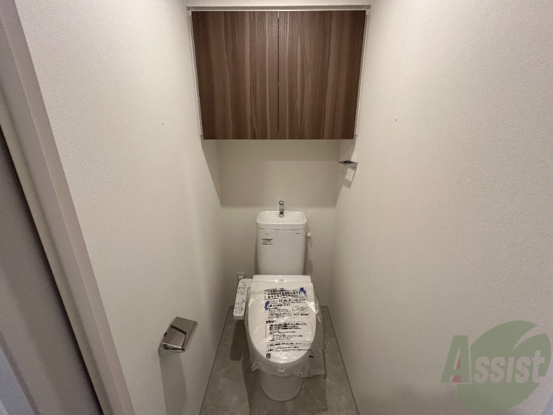 トイレ　トイレには温水洗浄便座がついています。上段に棚もありますね。