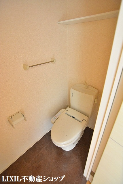 トイレ　上部に収納棚のある温水洗浄便座付のトイレです。