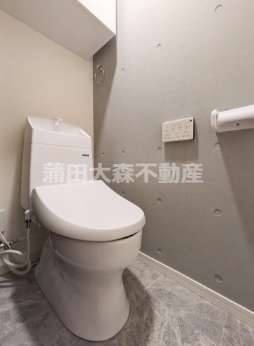 トイレ　吊戸棚と温水洗浄便座付きのトイレ