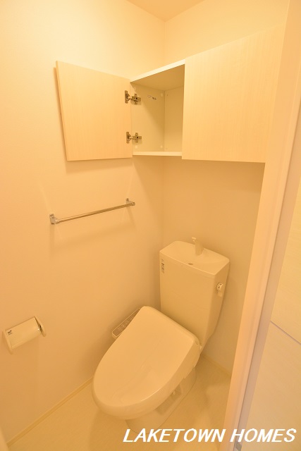 トイレ　上部に収納棚のある温水洗浄便座付のトイレです。