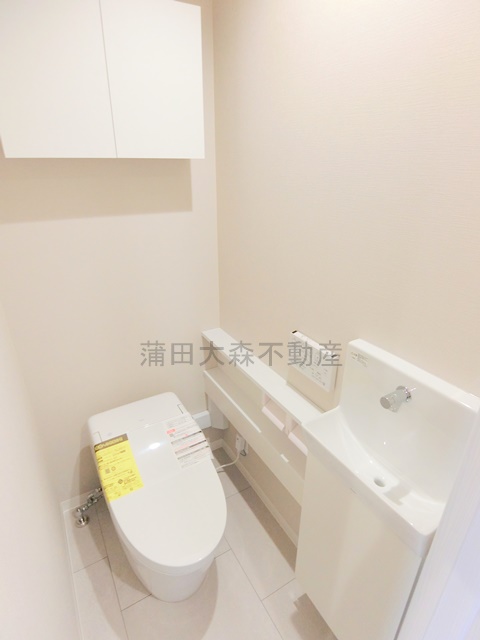 トイレ　棚と温水洗浄便座付きのトイレ