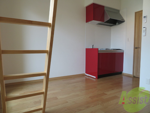 居室・リビング　赤いキッチンがアクセントになっているお部屋です。