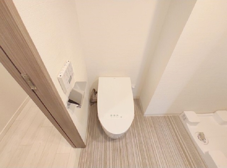 トイレ　吊戸棚収納と温水洗浄便座付きのタンクレストイレ