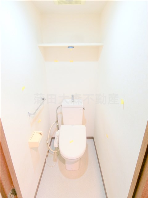 トイレ　棚と温水洗浄便座付きのトイレ