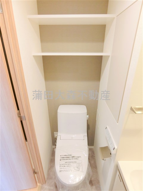 トイレ　吊戸棚と温水洗浄便座付きのトイレ