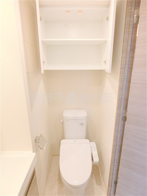 トイレ　吊戸棚収納と温水洗浄便座付きのトイレ