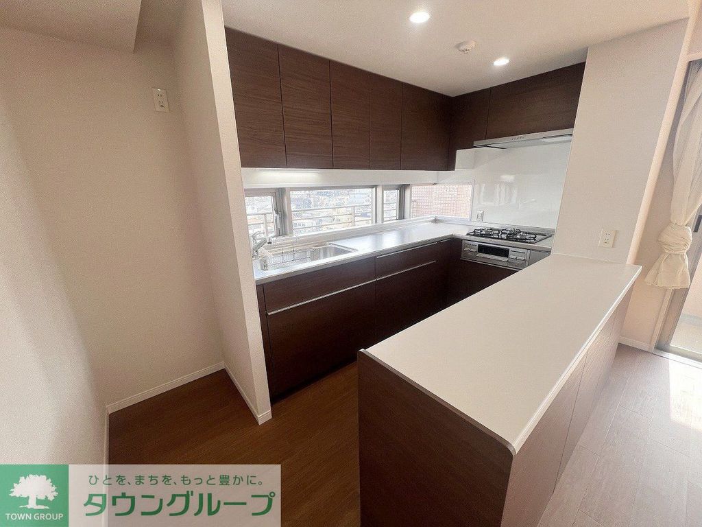 キッチン　窓から光が差し込むＬ型のシステムキッチンとキッチンカウンター