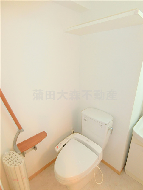 トイレ　棚と温水暖房便座付のトイレ