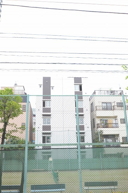 建物外観　建物裏手はテニスコートで和やかな雰囲気