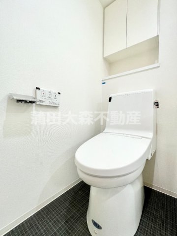 トイレ　吊戸棚と温水暖房便座付きのトイレ