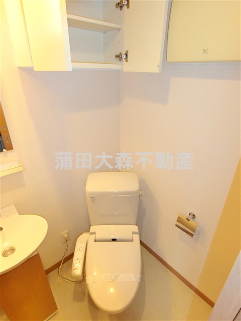 トイレ　吊戸棚と温水洗浄便座付きのトイレ
