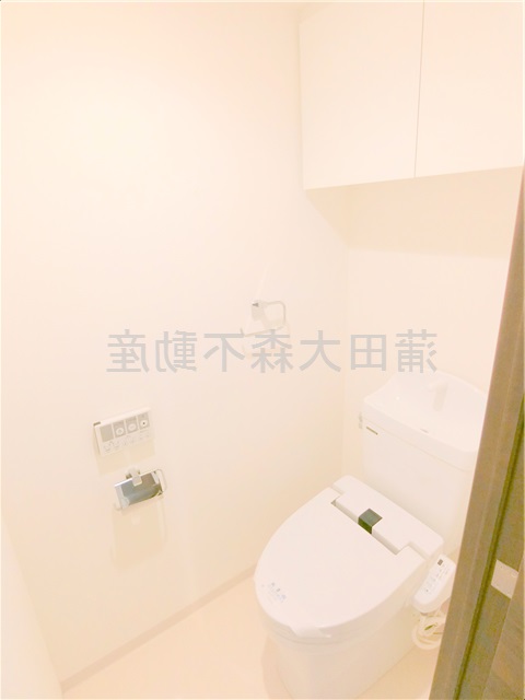 トイレ　上部棚収納に温水暖房便座付きトイレ