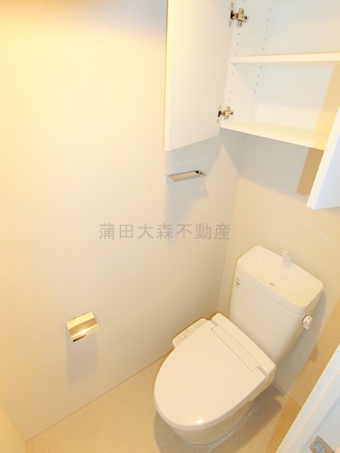 トイレ　吊戸棚収納と温水洗浄便座付きのトイレ