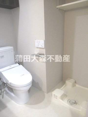 トイレ　吊戸棚と温水洗浄便座付きのトイレ