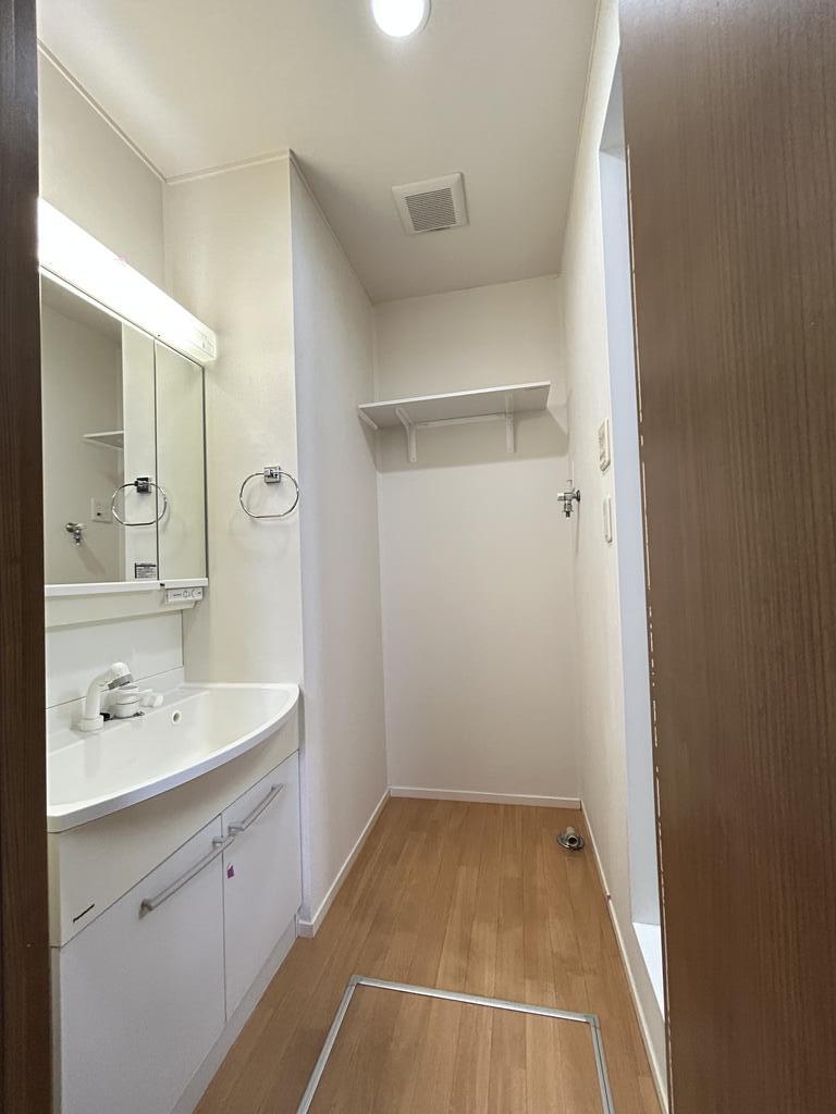 洗面設備　奥にある洗濯機置場の上には便利な棚がついています