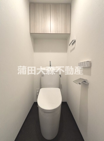 トイレ　吊戸棚収納と温水洗浄便座付きのトイレ