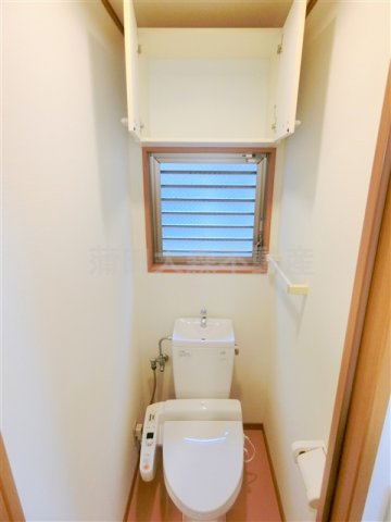 トイレ　窓と吊戸棚収納、温水洗浄便座付きのトイレ