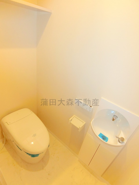 トイレ　棚と手洗い場、温水洗浄便座付きのトイレ