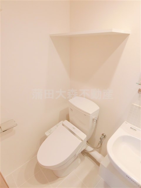 トイレ　棚と温水暖房便座付きのトイレ