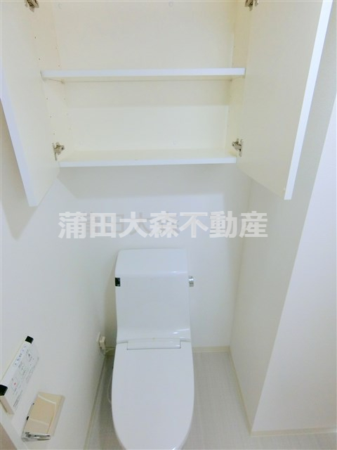 トイレ　吊り戸棚収納と温水暖房便座付きのトイレ