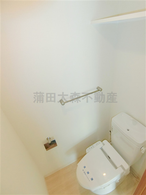 トイレ　棚と温水暖房便座付きのトイレ