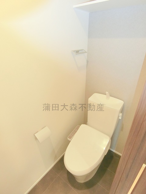トイレ　棚と温水洗浄便座付きのトイレ