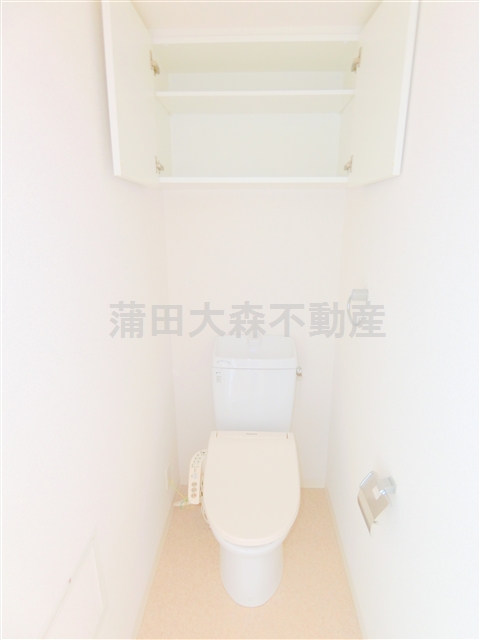 トイレ　吊戸棚と温水暖房便座付きのトイレ