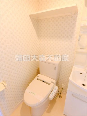 トイレ　棚と温水洗浄便座付きのトイレ