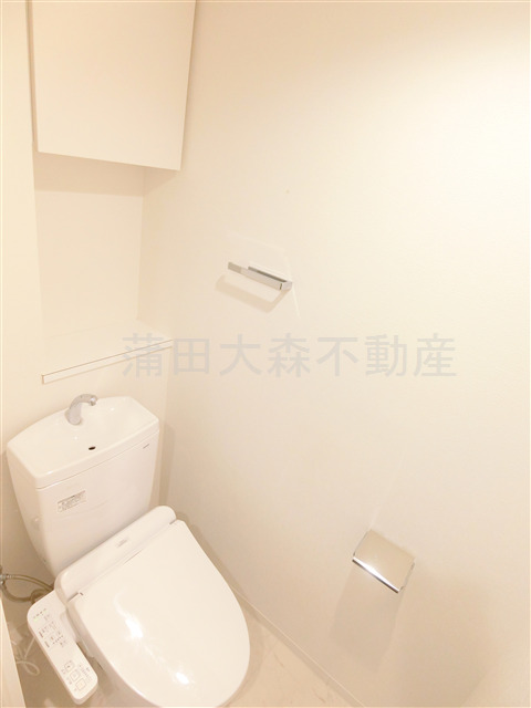 トイレ　吊戸棚収納と温水洗浄便座付きのトイレ