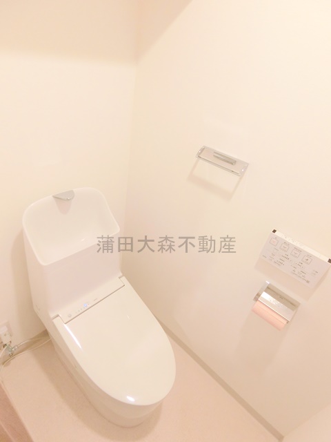 トイレ　棚と温水洗浄便座付きのトイレ