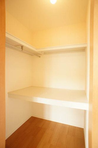 収納　ハンガーパイプと机棚を配したウォークインクローゼット