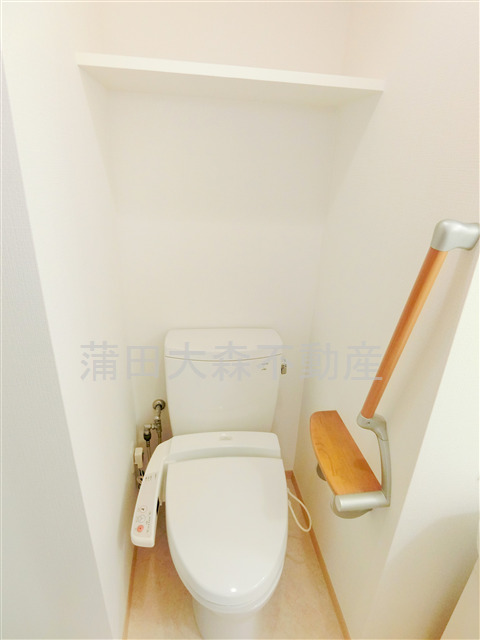 トイレ　棚と温水暖房便座付のトイレ