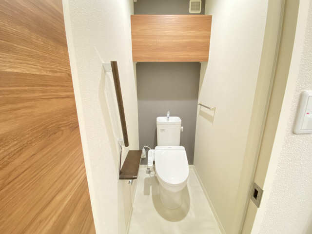 トイレ　手摺と上部には扉付き収納棚をご用意