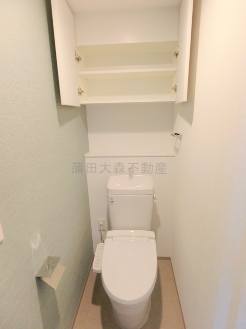 トイレ　吊戸棚と温水洗浄便座付きのトイレ