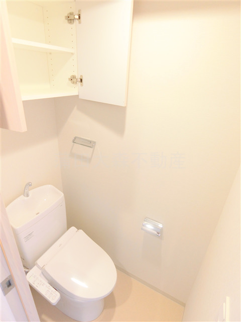 トイレ　吊戸棚と温水洗浄便座付きのトイレ