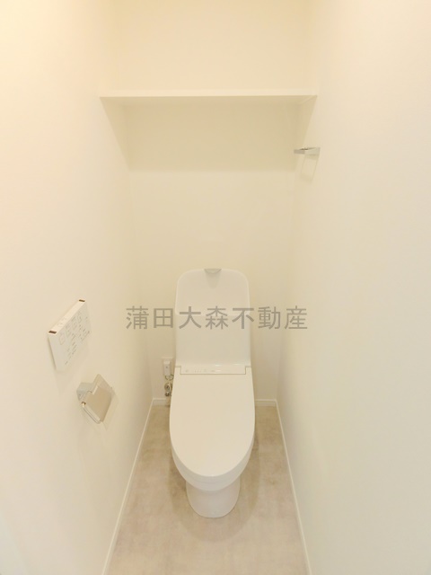 トイレ　棚と温水洗浄便座付きのトイレ