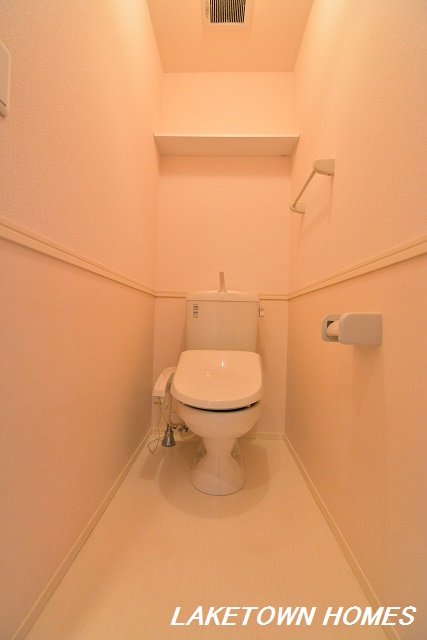 トイレ　上部に収納棚のある温水洗浄便座付のトイレです。