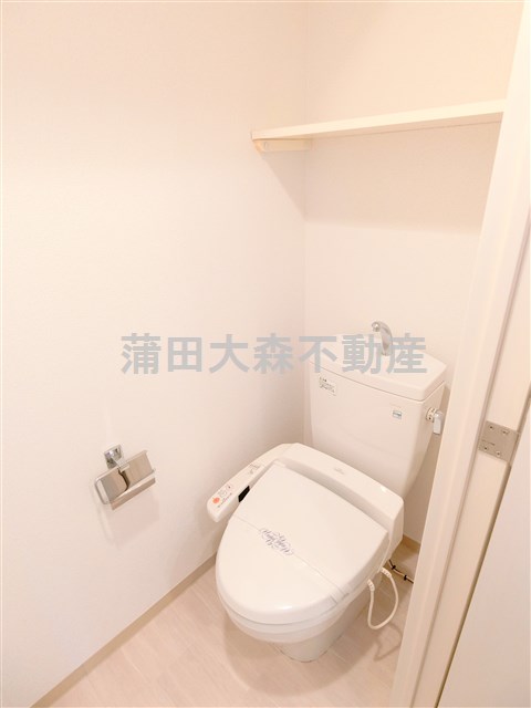 トイレ　棚と温水暖房便座付きのトイレ