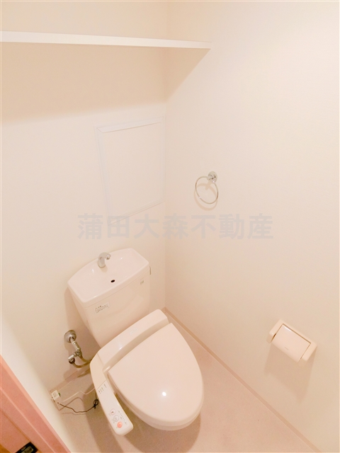 トイレ　棚と温水暖房便座付きのトイレ